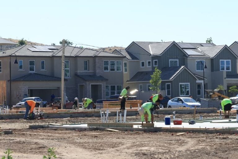 Crew working on site prep in front of a row of new two-story townhomes - HERS rating in Holyoke, MA