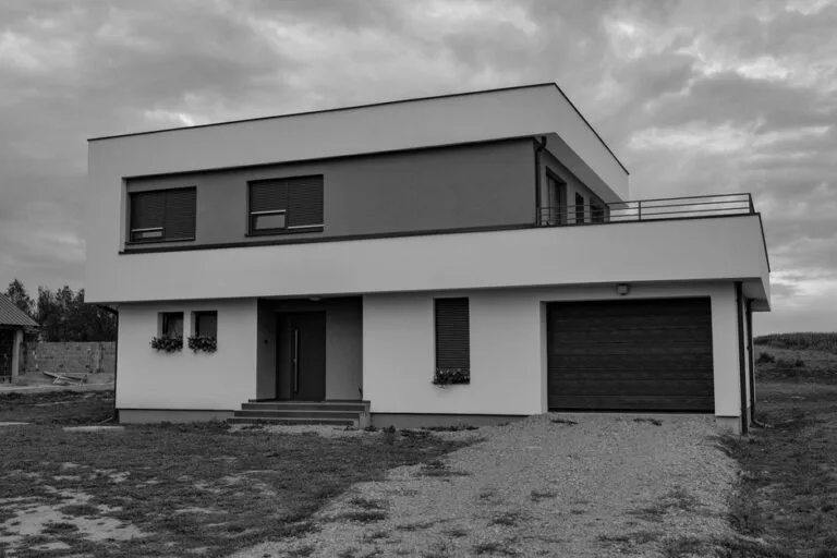 Black-and-white photo of a modern flat-roof two-story house with a garage - HERS rating in Mashpee, MA