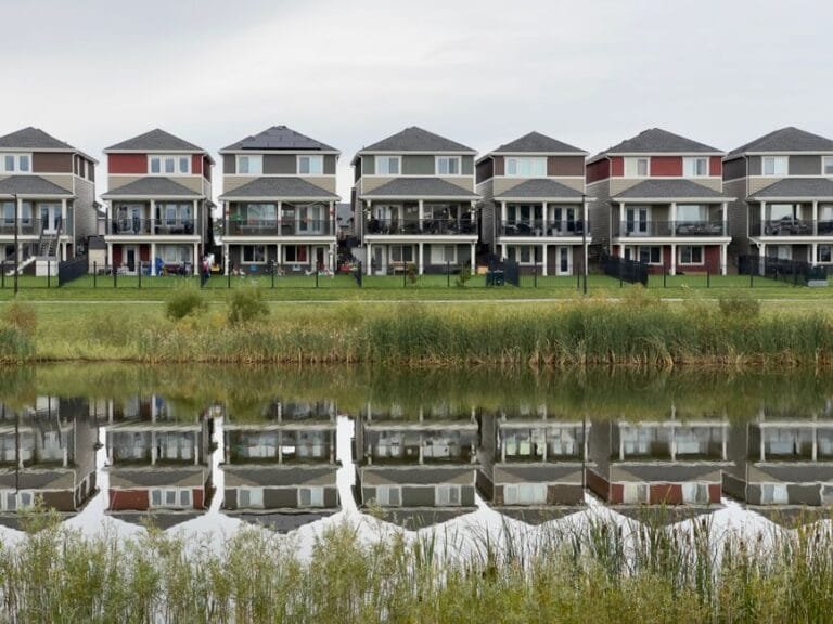 Row of new waterfront homes reflected in a pond - HERS rating in Ludlow, MA