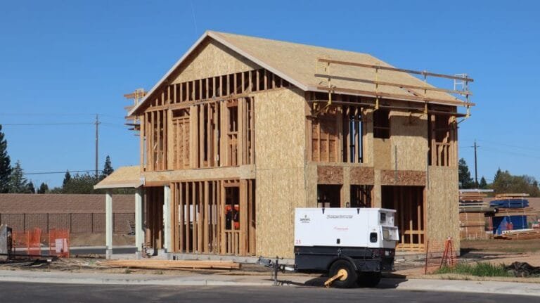 Two-story wood frame with roof trusses and a generator on a new home site - HERS rating in Arlington, MA