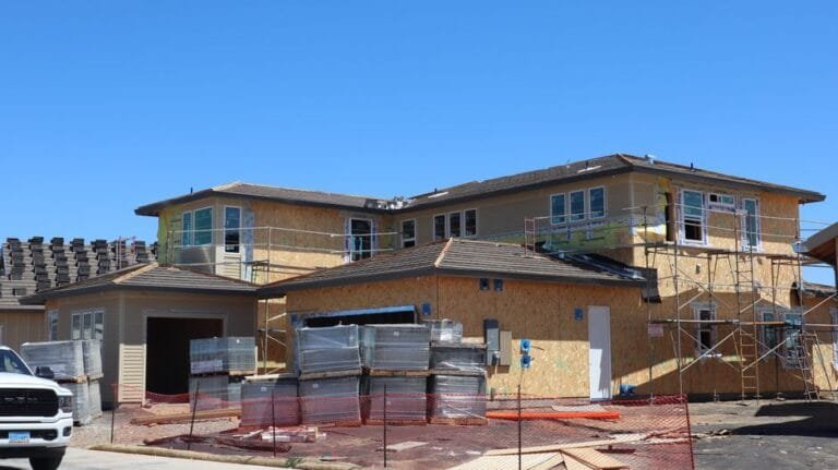 Multifamily building under construction behind orange safety fencing - HERS rating in Halifax, MA