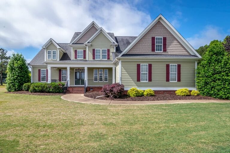 Green two-story home with red shutters and a wide front lawn - HERS rating in Amherst, MA