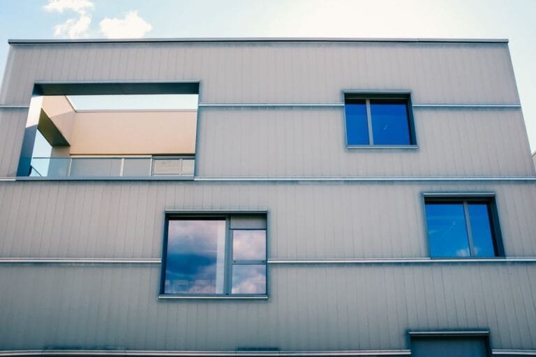 Close-up of a gray panel-clad modern facade with square windows - HERS rating in Malden, MA