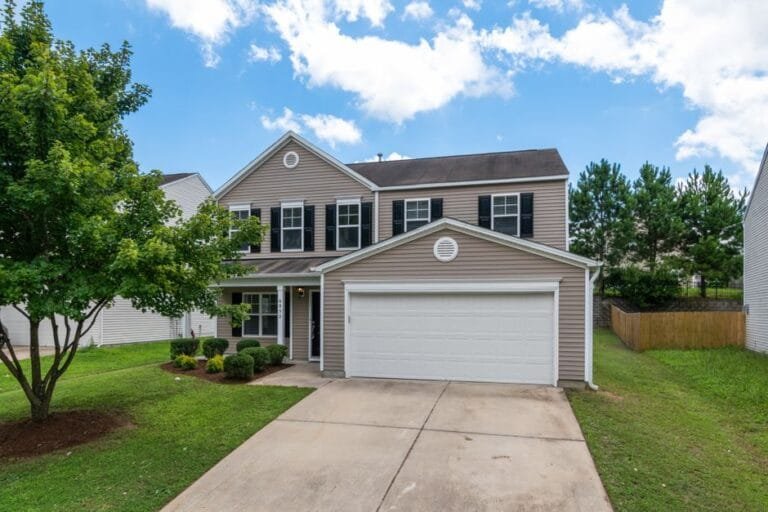 Gray two-story home with a white two-car garage and a long concrete driveway - HERS rating in Melrose, MA