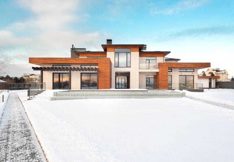 Modern wood-and-glass home with flat roofs in winter snow - HERS rating in Newbury, MA