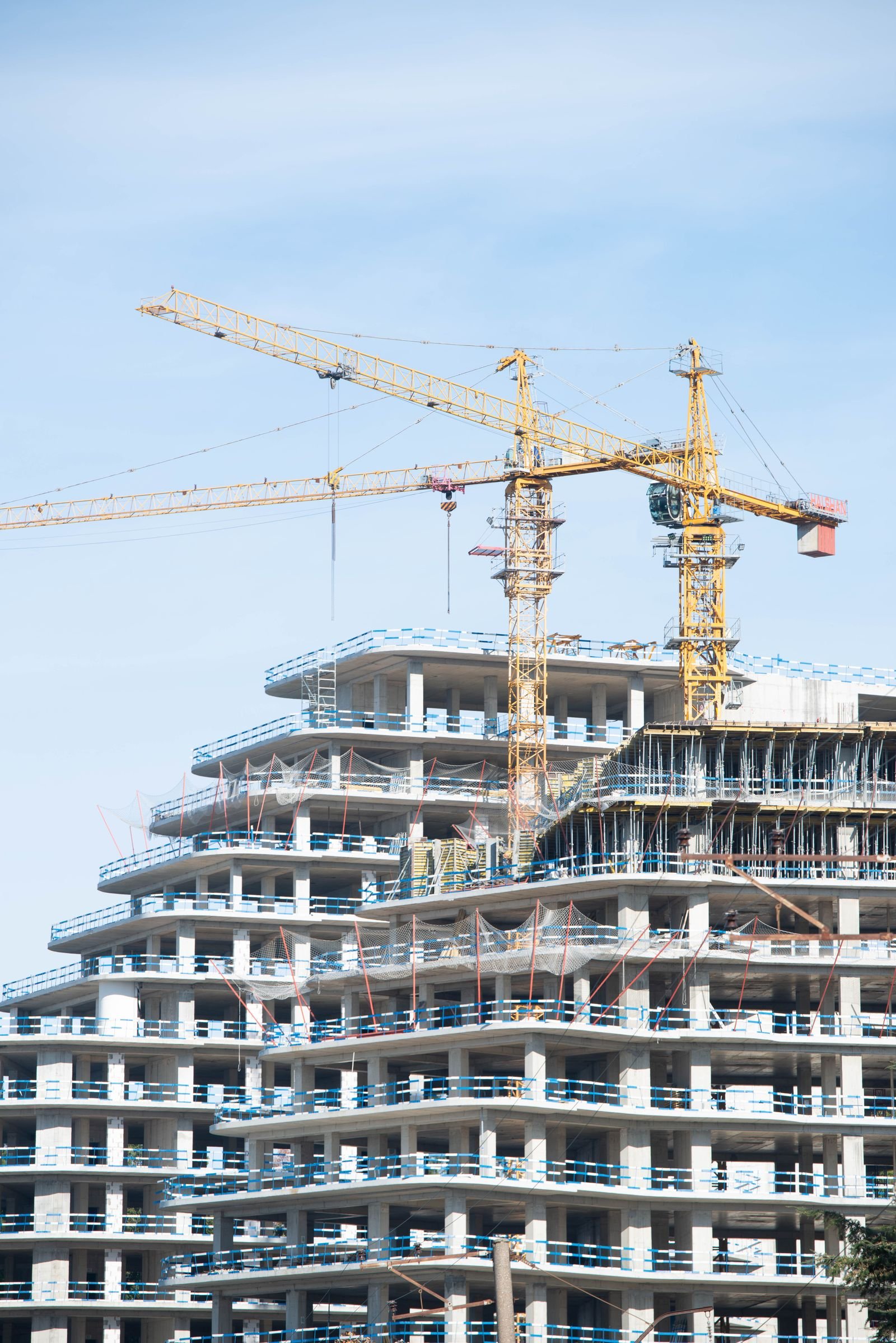 Residential tower under construction with tower cranes - Phius Passive House verification in Massachusetts