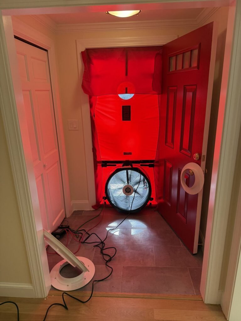 Blower door fitted in a front entry with the red door swung open - blower door testing in Lynn, MA