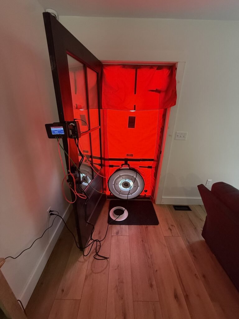 Blower door test underway with the gauge clipped to the open entry door – HEEC blower door testing for Tisbury, MA homes