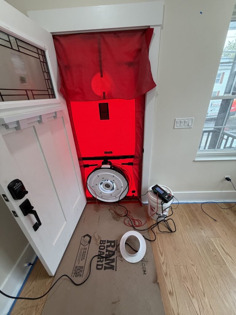 Blower door set up in a new home entry with floor protection board on the floor – HEEC blower door testing for Ashburnham, MA homes