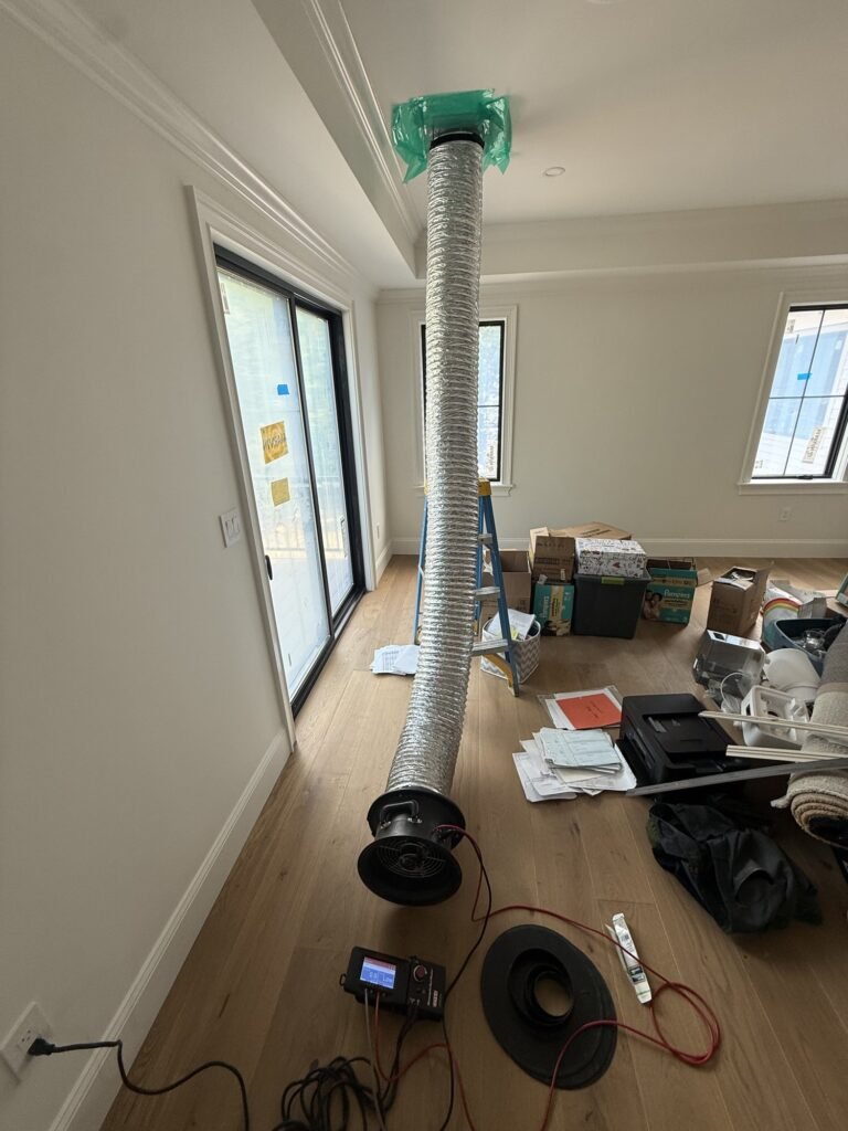 Flex duct riser connected to test equipment in a bright unfinished room - HERS rating in Chesterfield, MA