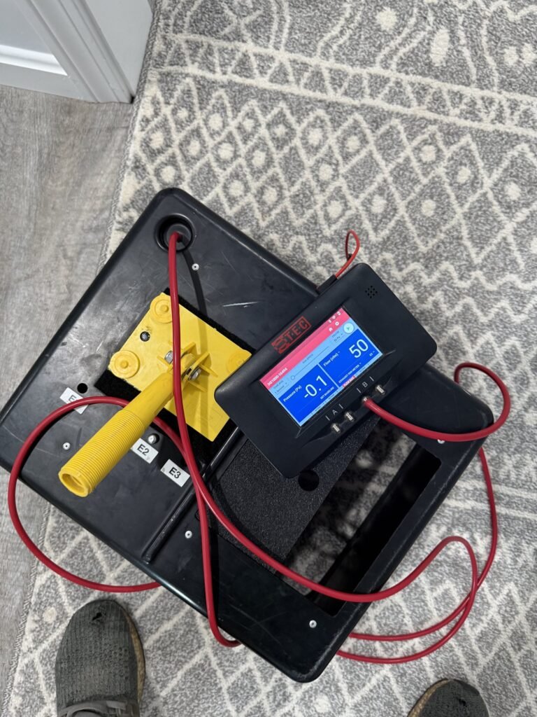 Duct test fan plate with a yellow flow ring and manometer on a rug - HERS rating in Hudson, MA