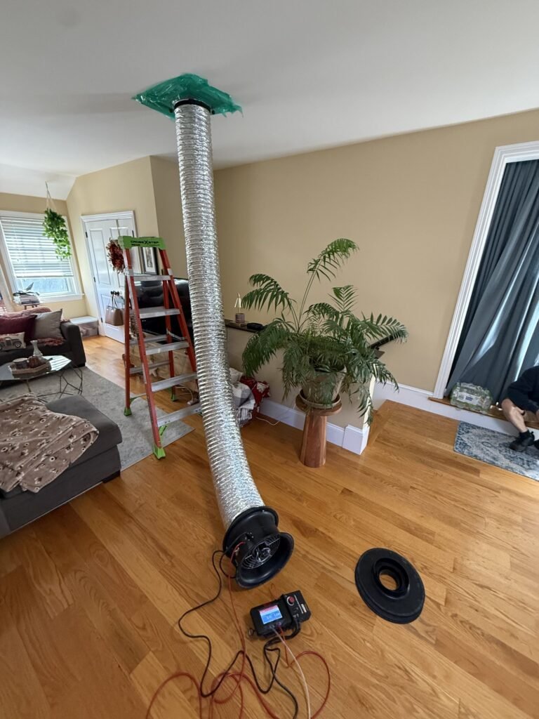 Tall flex duct from a ceiling register down to a test fan in a living room - HERS rating in Florida, MA