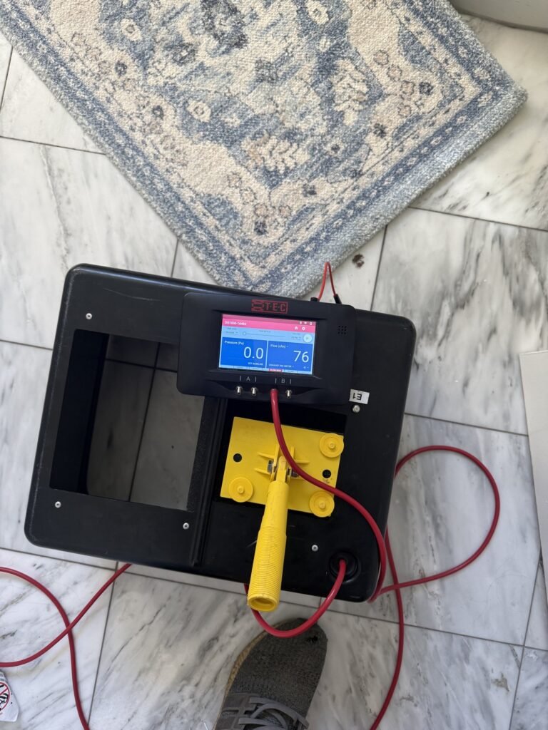 Duct test fan box with its gauge on a gray patterned rug - HERS rating in Eastham, MA