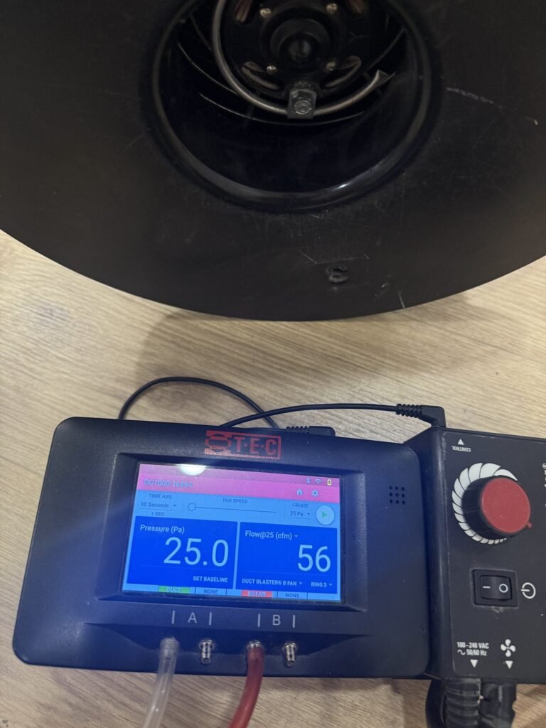 Manometer screen showing test pressure next to a duct testing fan - HERS rating in Hadley, MA