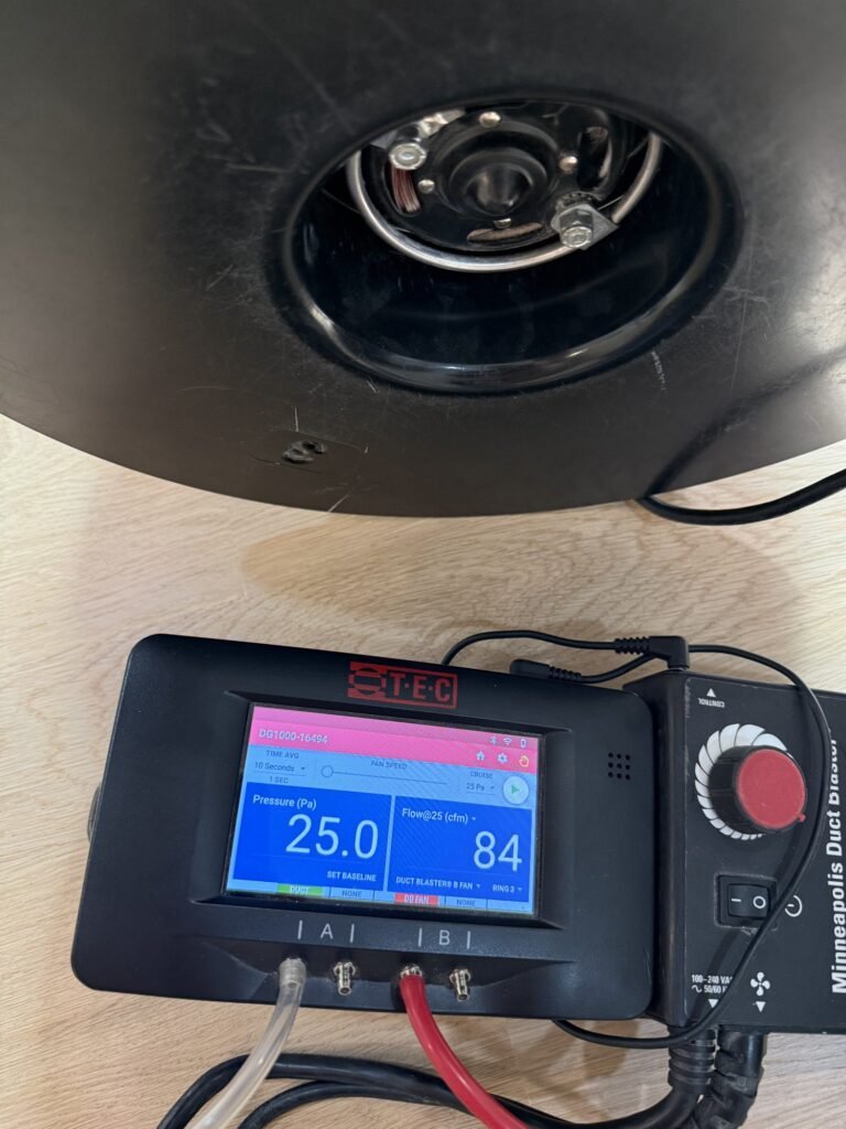 Manometer showing 84 CFM25 at 25.0 Pa on new white-oak flooring - duct leakage testing in Wellesley, MA