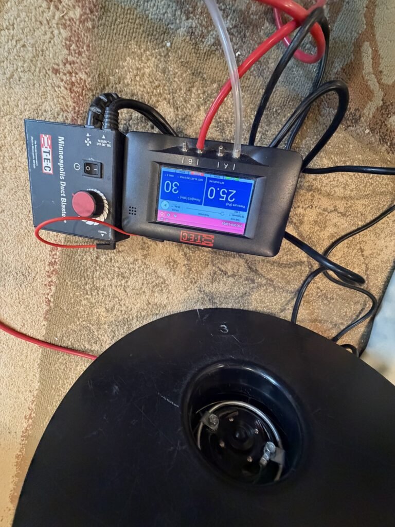 Overhead view of the Duct Blaster fan and DG-1000 manometer reading 30 CFM25 at 25 Pa – HEEC duct leakage testing for Richmond, MA homes