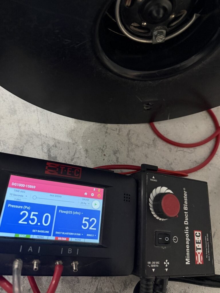 Duct Blaster gauge at 25 Pa test pressure reading 52 CFM25 of total duct leakage on a protected floor – HEEC duct leakage testing for Rowley, MA homes