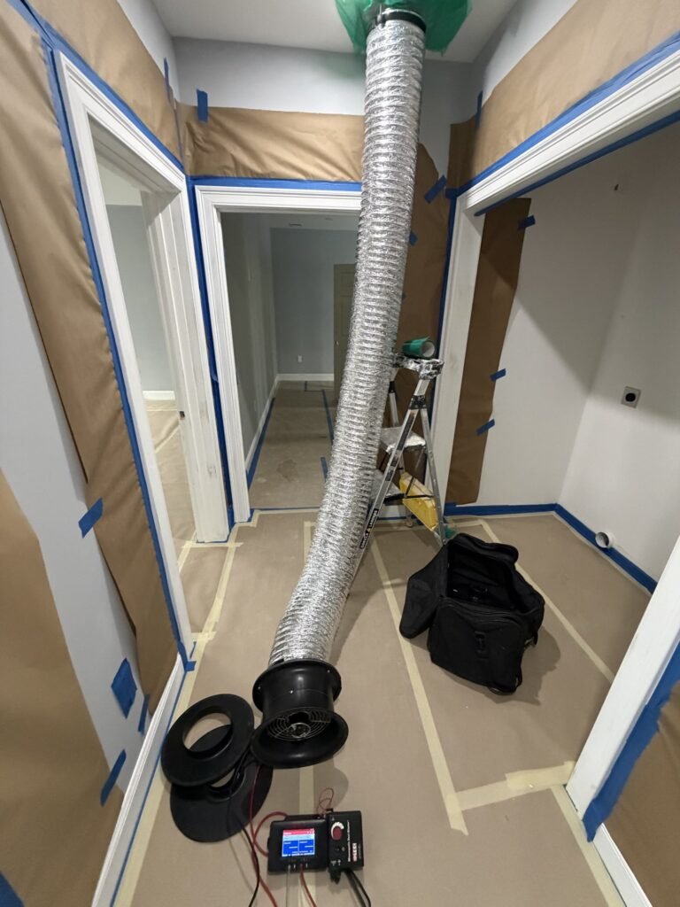 Duct Blaster hose run through a hallway with floor protection to a sealed ceiling return – HEEC duct leakage testing for Richmond, MA homes