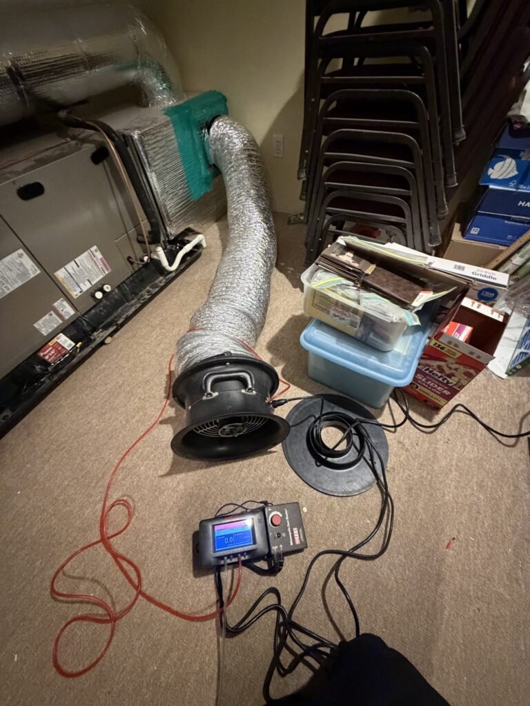 Duct Blaster hooked to the air handler in a basement storage room - duct leakage testing in Worcester, MA