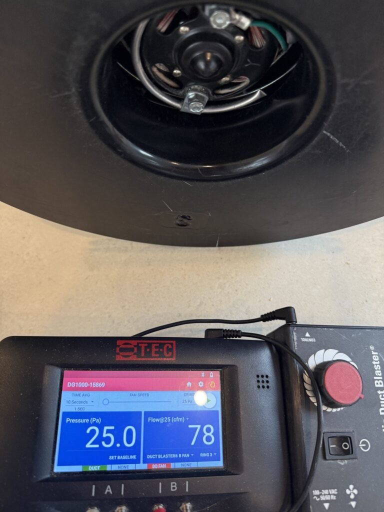 Close-up of the manometer at 25 Pascals with the Duct Blaster fan inlet behind it - duct leakage testing in Agawam, MA