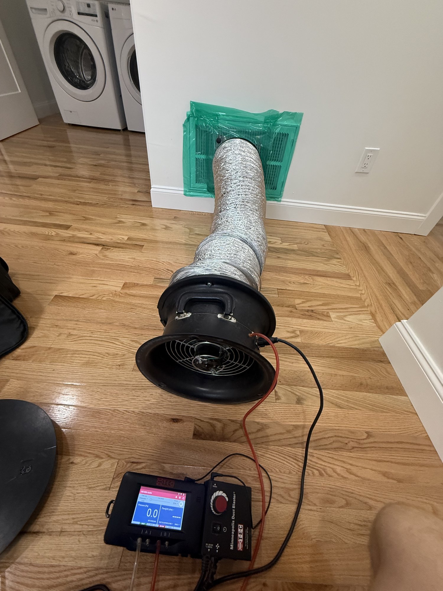 Duct Blaster fan connected to a return grille for a duct leakage test in a new Massachusetts home