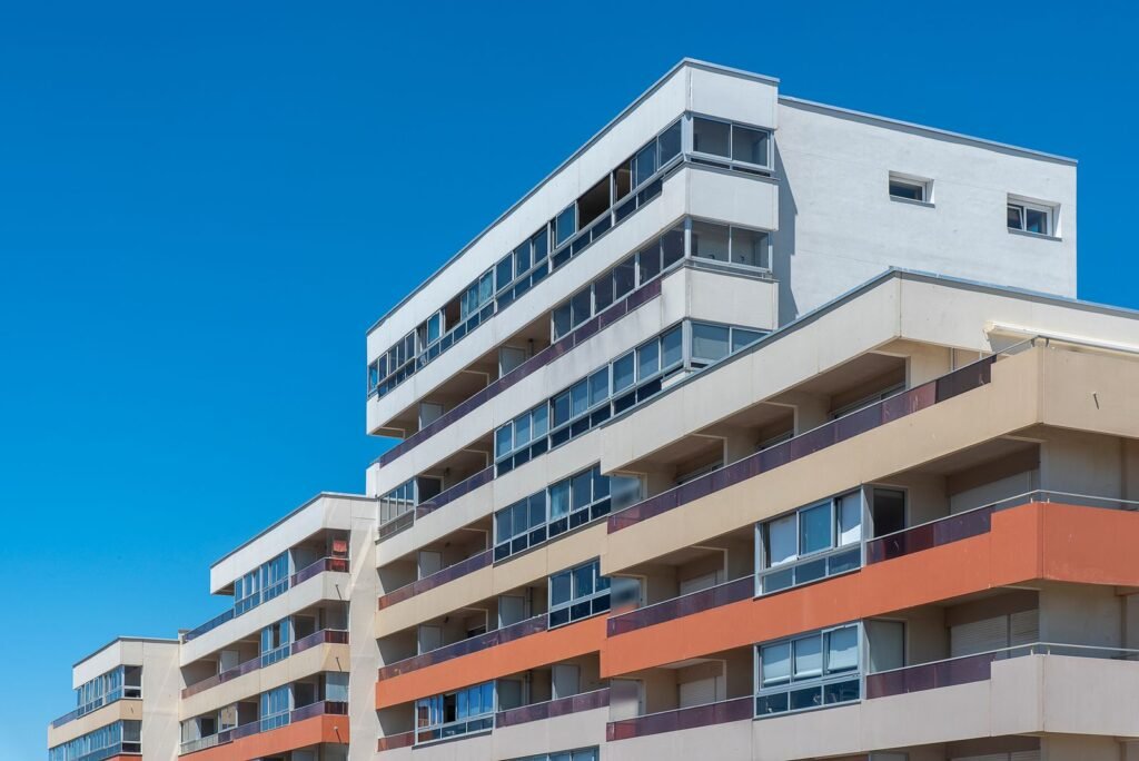 White apartment buildings with rows of balconies under a blue sky - HERS rating in Holliston, MA
