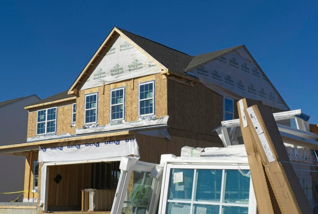 Partly sheathed house with an OSB gable and new windows stacked out front - HERS rating in Brookfield, MA