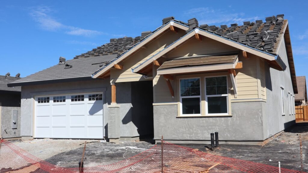 Nearly complete single-story stucco home with a white garage door - HERS rating in Hampden, MA