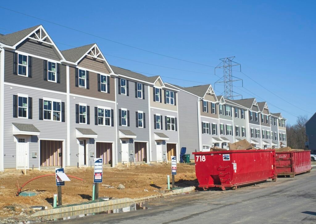 Vinyl-sided townhouse row under construction with a dumpster at the curb - HERS rating in Ashby, MA