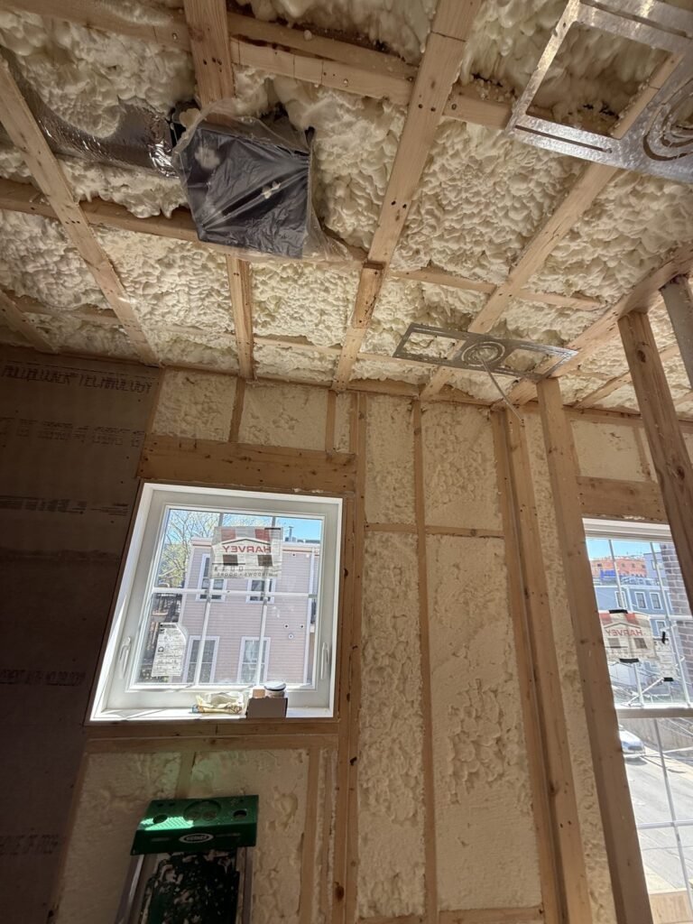 Spray-foamed walls and ceiling around a window with its label still on - HERS rating in Marblehead, MA