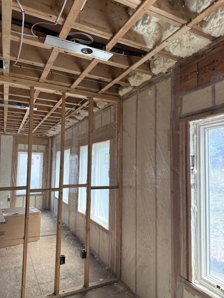 Spray-foamed walls around a row of window openings in a renovation - HERS rating in Gloucester, MA
