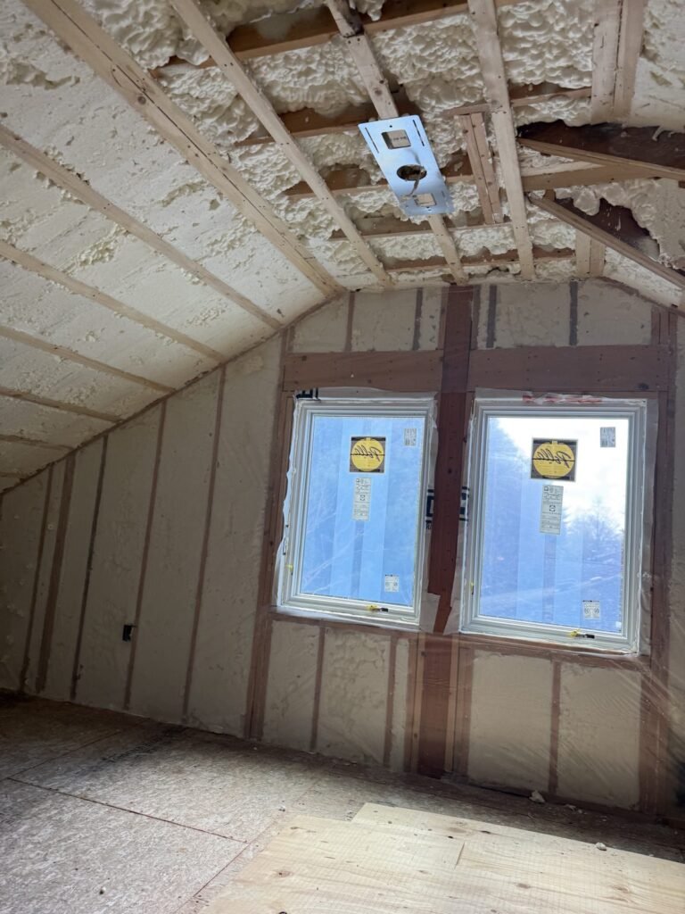 Foamed attic walls around a new double window - HERS rating in Bolton, MA
