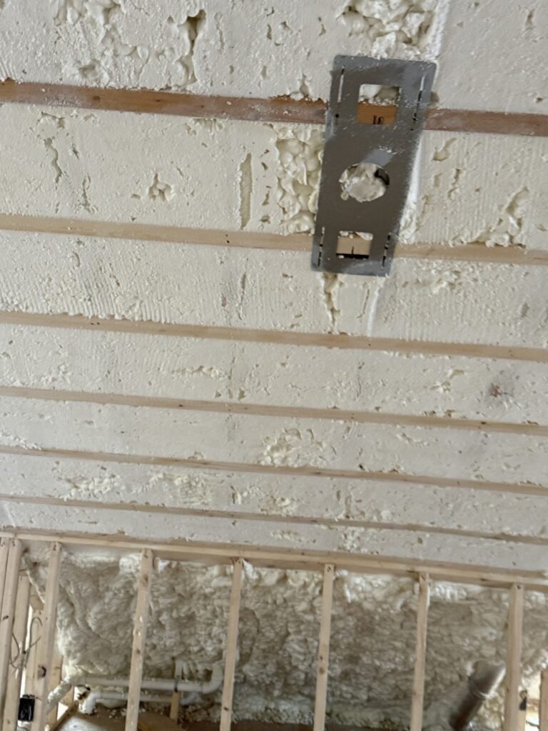 Close-up of spray foam on a sloped attic ceiling above strapping - spray foam insulation in Nantucket, MA