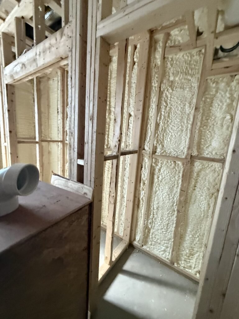 Foam-filled wall bays beside a PVC drain pipe - HERS rating in Brookfield, MA