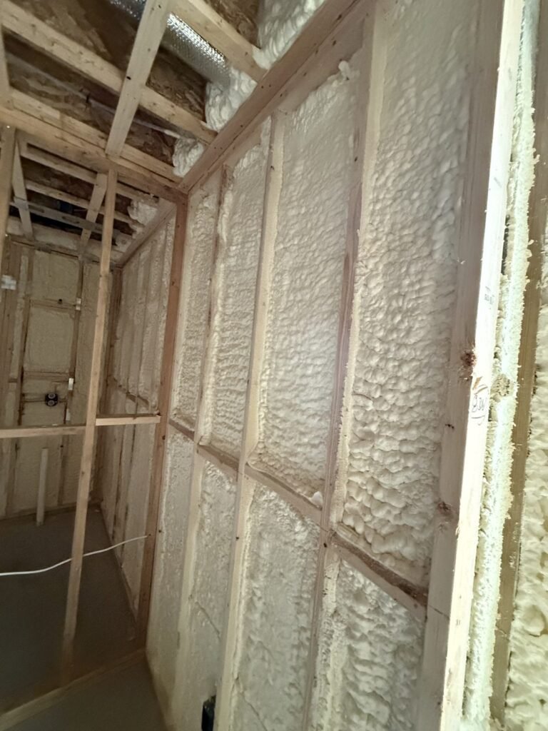 Spray foam filling wall cavities in a basement room - spray foam insulation in Wellfleet, MA