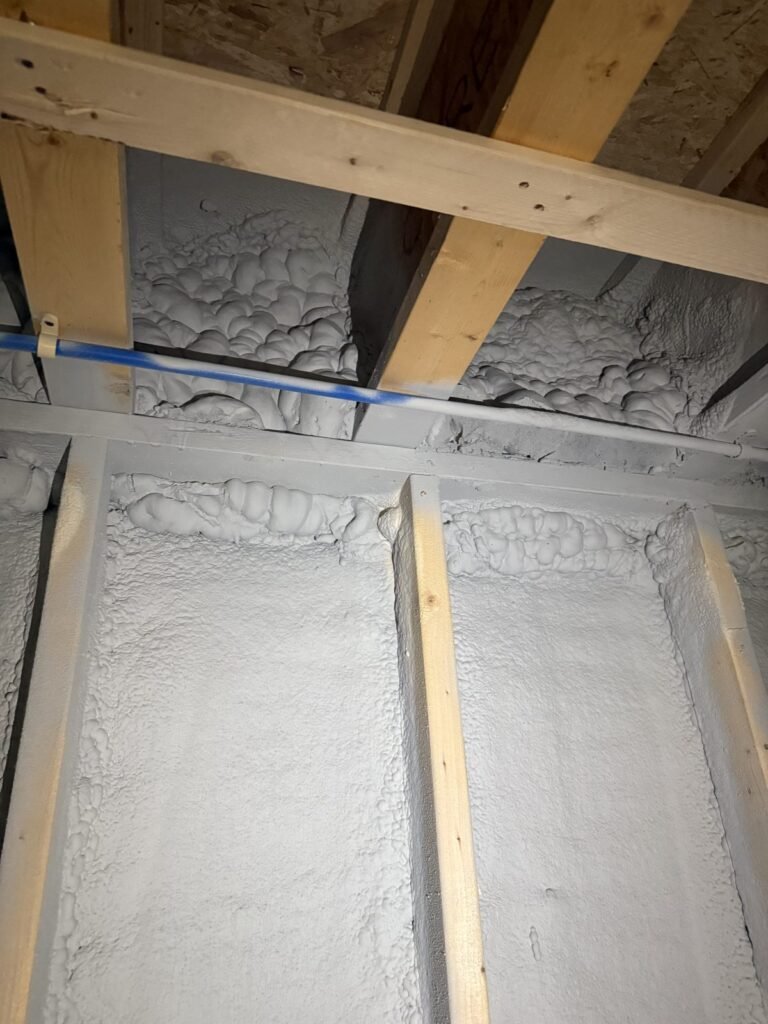 Spray foam sealing the rim joist above basement wall framing - spray foam insulation in Reading, MA
