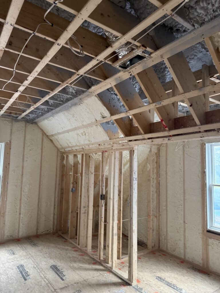 Upper room with spray-foamed walls beneath a sloped, strapped ceiling - HERS rating in Natick, MA