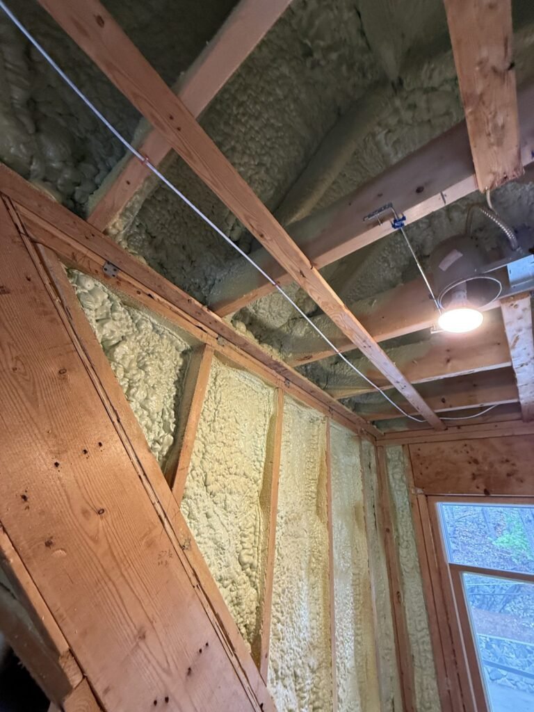 Spray-foamed cathedral ceiling and wall beside a window in an addition - HERS rating in Peabody, MA