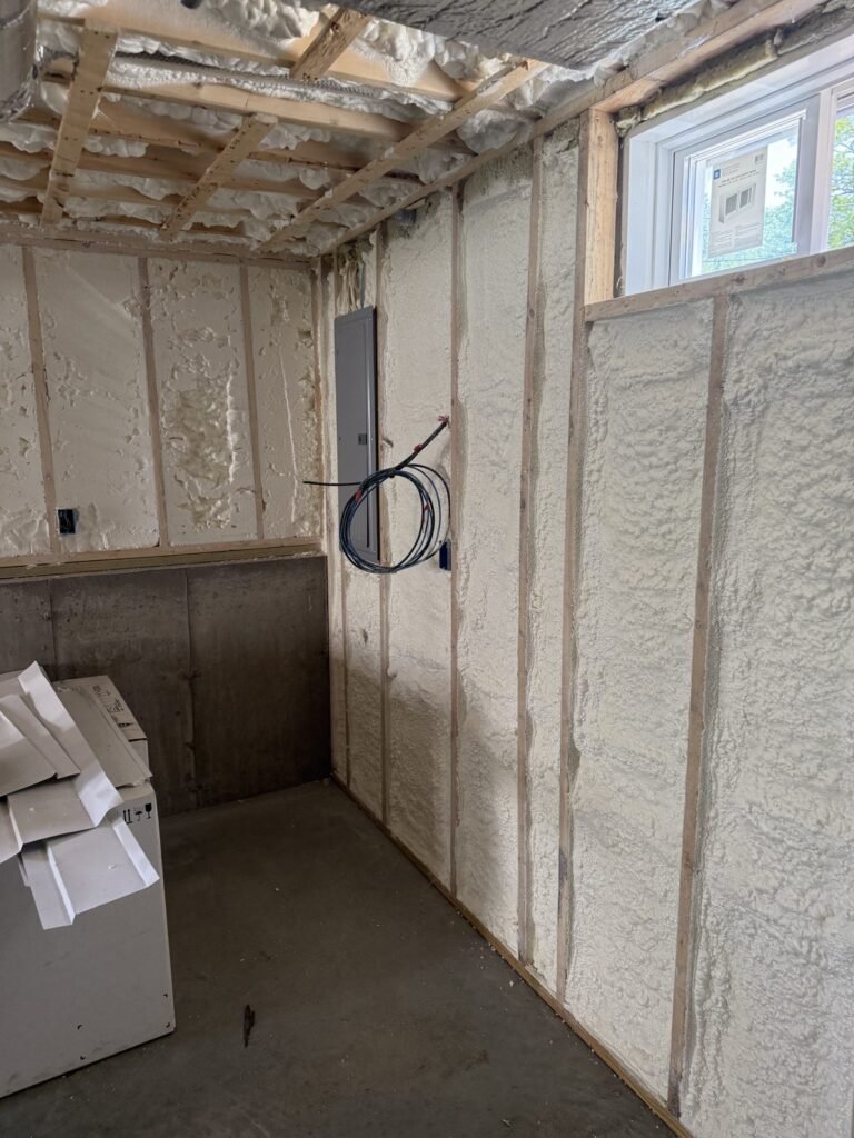 Foamed walls and ceiling in a utility corner with an electrical box - HERS rating in East Bridgewater, MA