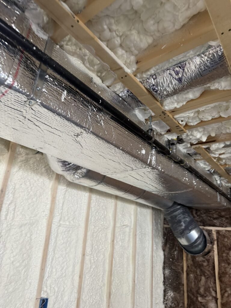 Foil duct run along a ceiling edge above a foamed wall - spray foam insulation in Marshfield, MA