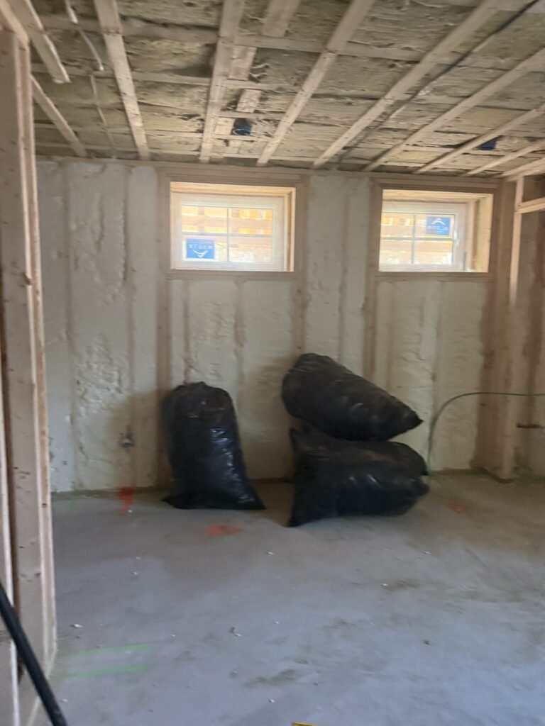 Spray-foamed walls in a lower-level room with two small windows - HERS rating in Springfield, MA