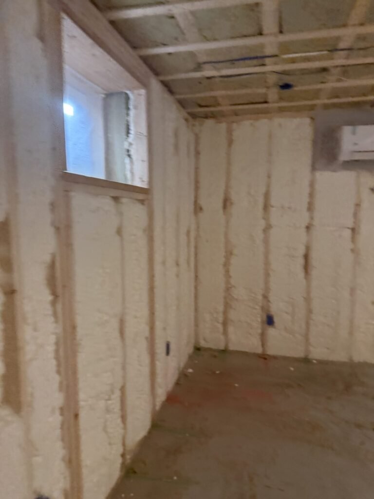 Foamed room corner with a high window and ductless wall unit - HERS rating in Alford, MA