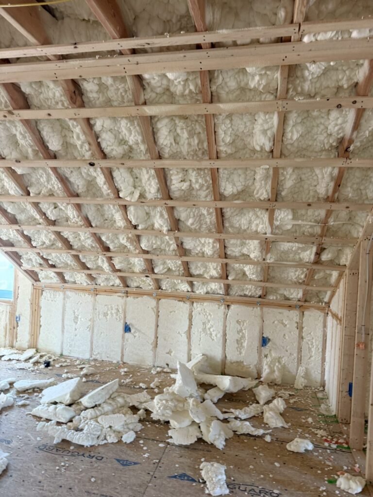 Attic room with foam on the roof slopes and trimmed foam scraps on the floor - HERS rating in Cohasset, MA