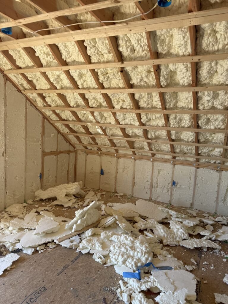 Foamed sloped attic ceiling with trimmed foam scraps on the floor - HERS rating in Boxford, MA