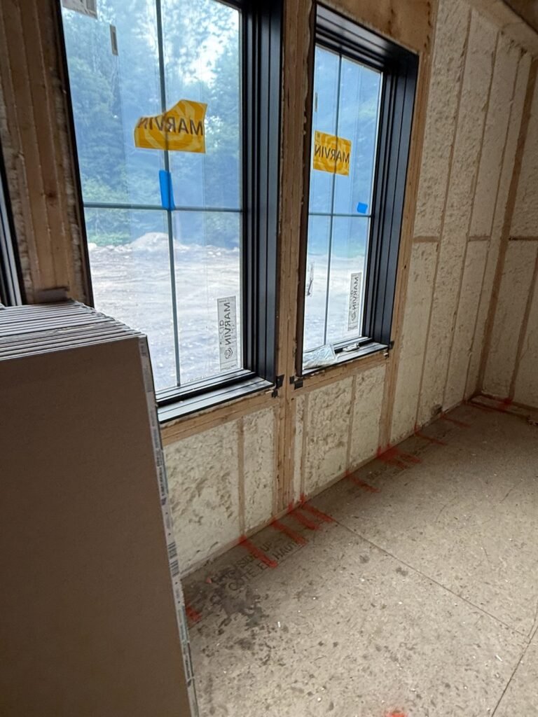Spray foam walls around tall black-frame windows - spray foam insulation in Longmeadow, MA