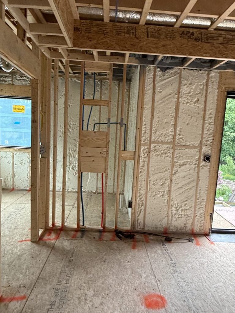 Wiring runs across a spray-foamed wall in an open interior - HERS rating in Fall River, MA