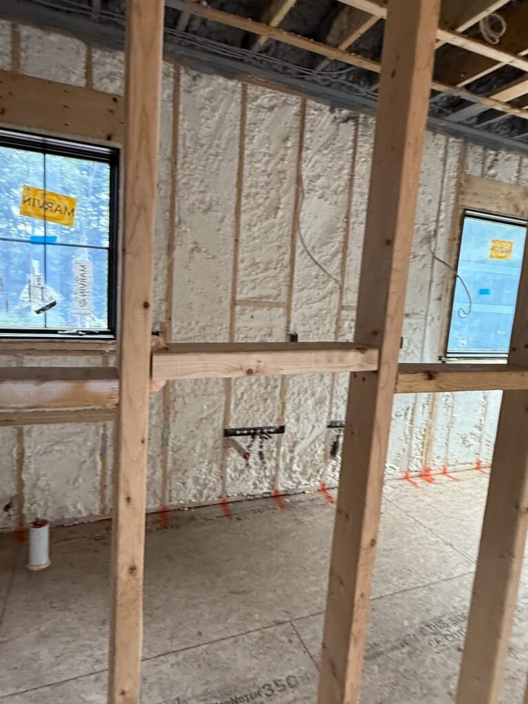Spray foam exterior walls around two new windows in an open room - spray foam insulation in Holbrook, MA