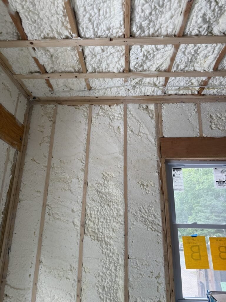 Narrow room with foamed walls and a strapped ceiling facing a window - HERS rating in Clinton, MA