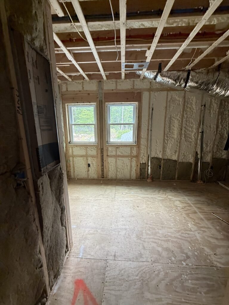 New room with spray-foamed walls under a strapped ceiling and twin windows - HERS rating in Woburn, MA