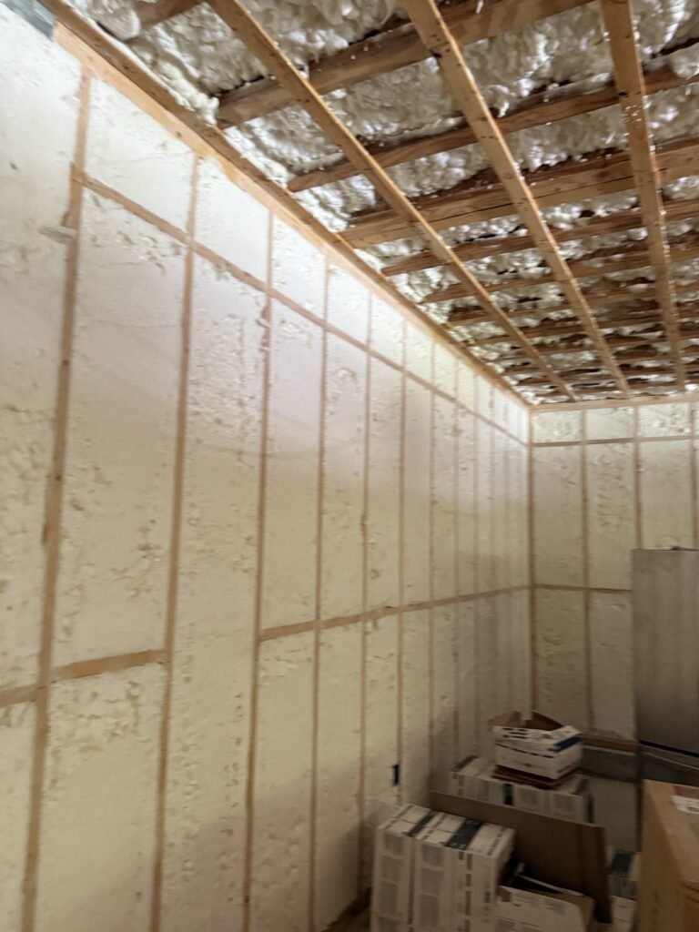 Long room with spray-foamed walls, a strapped ceiling and stacked tile boxes - HERS rating in Mendon, MA